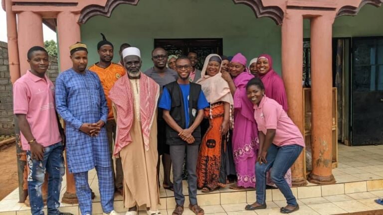 Participants pose together outside a building during a community visit.