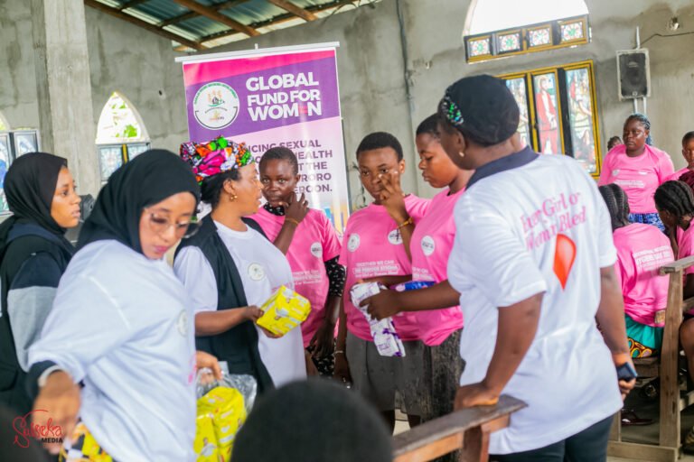 Participants gather around educational materials during a reproductive health outreach activity.