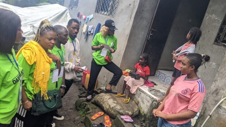 Outreach workers meet with residents beside their homes during a community visit.