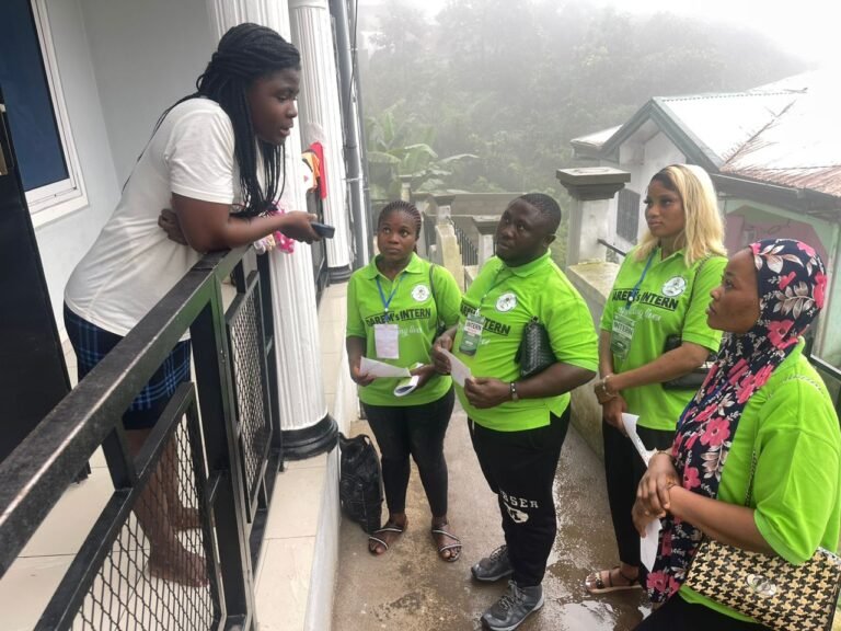 DAREM outreach workers discuss health information with a resident on a veranda.