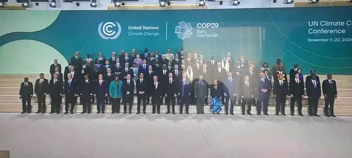 Delegates pose for a group photograph in front of a COP29 conference backdrop.