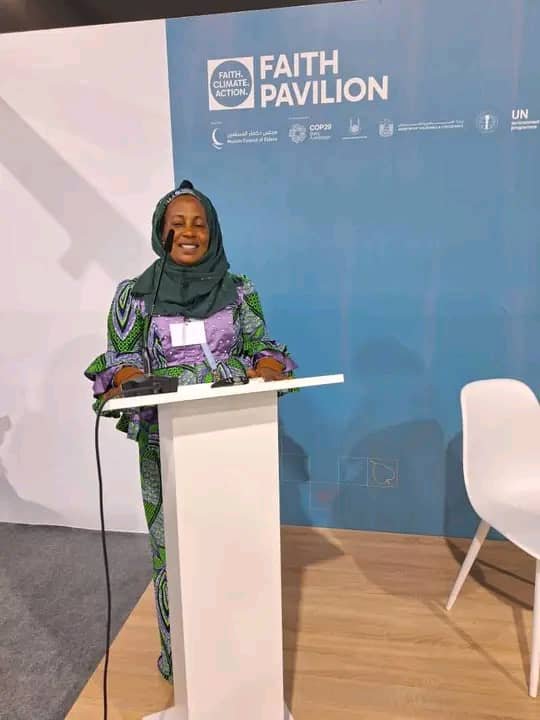 A speaker addresses an audience from a lectern at the COP29 Faith Pavilion.