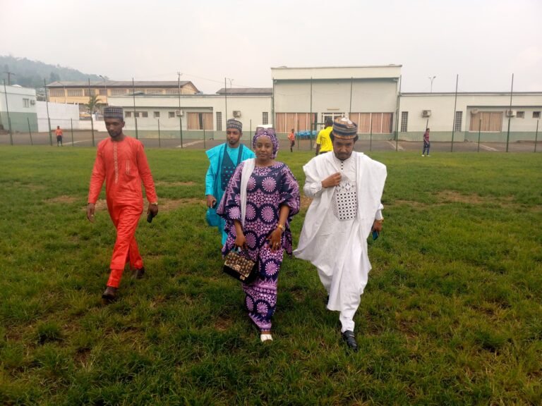 Organizers walk across the football pitch together.