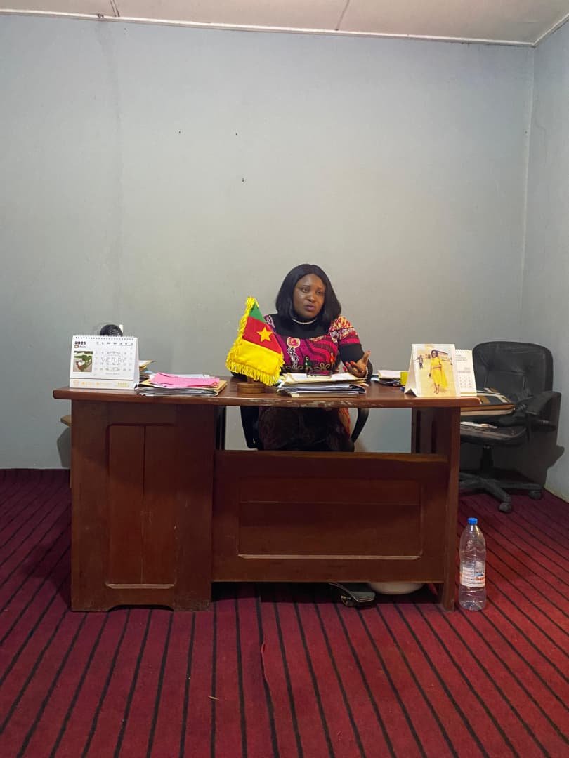 A person works at an office desk during a stakeholder visit.